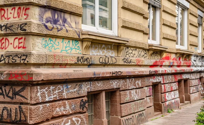 Mit Graffiti besprühte Gebäudefassade vor der fachgerechten Reinigung